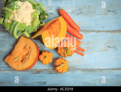 Pumpkin muscat, simple et décorative, les carottes et les choux-fleurs sur un fond de bois bleu rustique. la saine alimentation végétarienne, concept. Banque D'Images