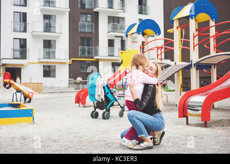 Une mère de famille sur l'aire de jeux Banque D'Images