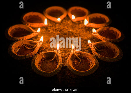 Happy diwali et cercle de diya - beaucoup de diyas en terre cuite ou lampes à huile disposées sur surface de l'argile ou terre ronde ou en forme circulaire, selective focus Banque D'Images