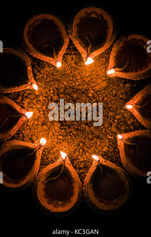 Happy diwali et cercle de diya - beaucoup de diyas en terre cuite ou lampes à huile disposées sur surface de l'argile ou terre ronde ou en forme circulaire, selective focus Banque D'Images