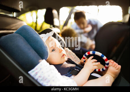 Little baby girl attaché avec la ceinture de sécurité en voiture de sécurité conducteur. Banque D'Images