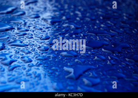 Gouttes d'eau sur une surface bleue Banque D'Images