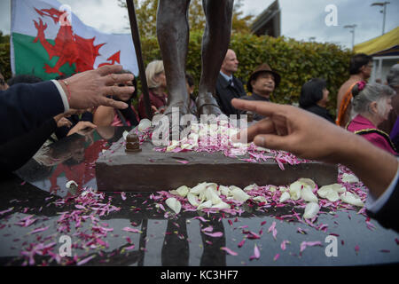 Personnes réparties pétales de fleurs au pied d'une statue du mahatma Gandhi, c'est dévoilé dans la baie de Cardiff, Pays de Galles, pour marquer le jour de sa naissance en 1869, et la Journée internationale de la non-violence qui est également célébrée le 2 octobre. Banque D'Images