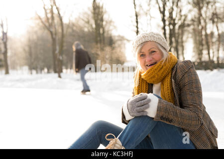 Senior woman avec mari dans la nature d'hiver patinage sur glace. Banque D'Images