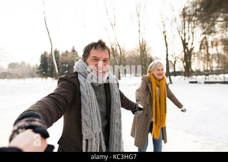 Senior couple in sunny winter nature du patinage sur glace. Banque D'Images