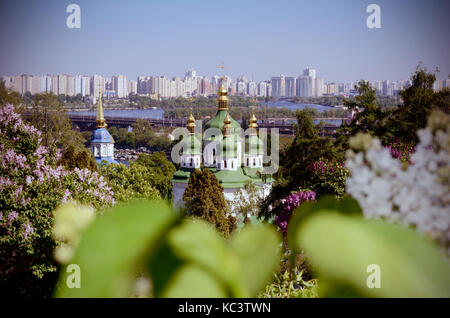 Église du Monastère Vydubychi parmi les buissons de lilas en fleurs au printemps. Kiev, Ukraine. Film vintage photo filtrée Banque D'Images