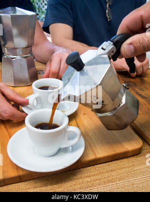 Le café moulu dans une macchinetta traditionnellement est versé dans une tasse de café. Banque D'Images