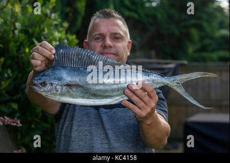 Angler Mark Padfield qui ont pris les premiers poissons dauphins dans les eaux britanniques, à partir de la plage de Chesil dans le Dorset. Le poisson n'est pas indigène à la France eaux. Banque D'Images