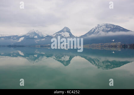 Montagne se reflétant dans les eaux du lac Wolfgangsee, toujours sous un ciel couvert le printemps. vue depuis st. Wolfgang, Autriche. Banque D'Images