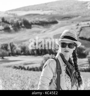 Découvrir une vue magique de la toscane. active woman in hat avec sac Randonneur admirant vue toscane Banque D'Images