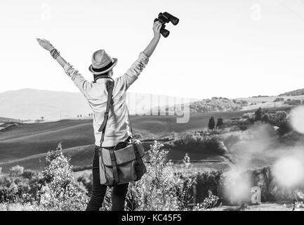 Découvrir une vue magique de la toscane. vu de dos femme sac randonneur avec randonnées en Toscane avec des jumelles réjouissance Banque D'Images