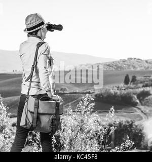 Découvrir une vue magique de la toscane. vu de dos randonneur avec sac femme profitant de la toscane à la vue dans la distance avec des jumelles Banque D'Images