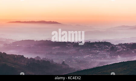 Paysage avec le Ciel de coucher du soleil au-dessus de couches de foggy mountains Banque D'Images