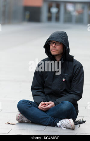 Manchester, UK. 2Nd Oct, 2017. Un 'Meditation Flash Mob' mettre son mégot sur le trottoir froid à l'extérieur de la bibliothèque John Ryland, Deansgate, Manchester, UK pour instaurer la paix dans le monde le deuxième jour de protestation contre la politique conservatrice de la guerre contre d'innocents brown hommes femmes et enfants dans le monde entier. Credit : Graham M. Lawrence/Alamy Live News Banque D'Images