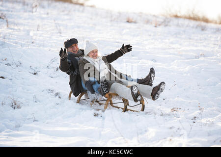 Beau couple sur un traîneau s'amusant, journée d'hiver. Banque D'Images