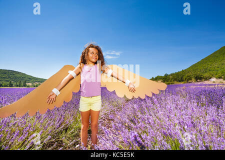 Funny Girl faisant semblant d'être un oiseau, debout dans champ de lavande dans son costume fait main Banque D'Images