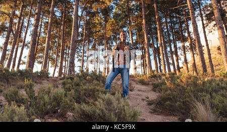 Jeune homme africain debout sur un sentier forestier Banque D'Images