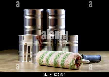 Pots de peinture sur un atelier en bois. table suivant pour les pédales et rouleaux à peinture. fond noir Banque D'Images