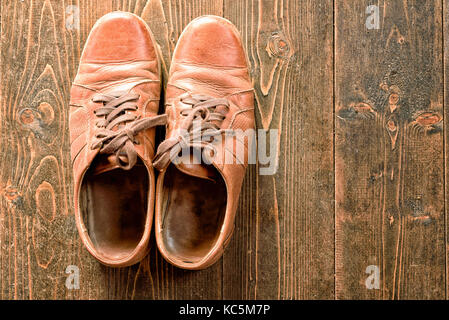Ancienne et bien porté des chaussures en cuir brun sur un fond en bois rustique avec copie espace salon pour les conceptions basées sur la mode et les thèmes Banque D'Images