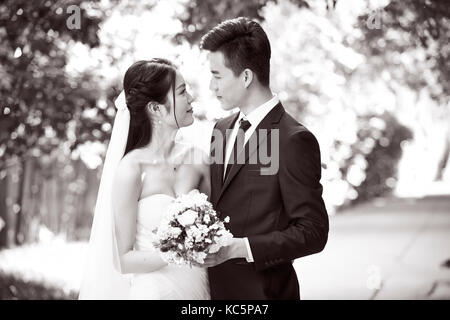 Outdoor portrait of asian Bride and Groom, heureux et souriants, noir et blanc. Banque D'Images