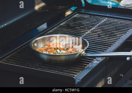 Légumes : carottes, haricots verts, chou, champignons sautés dans une poêle sur le grill en plein air. Banque D'Images