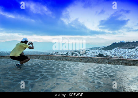 Sportsman l'observation d'une vue panoramique de ville bleue de Chefchaouen au Maroc, la hausse Banque D'Images