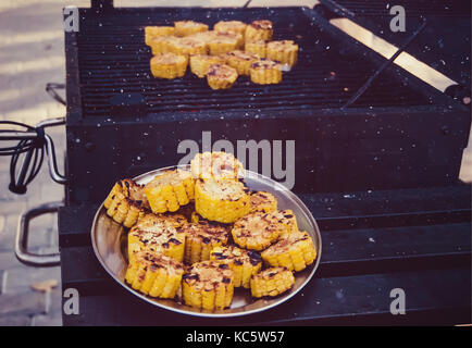 Golden delicious des épis de maïs grillé servi en plein air. La plaque de métal de maïs sur le fond de la grille avec des légumes grillés. Banque D'Images