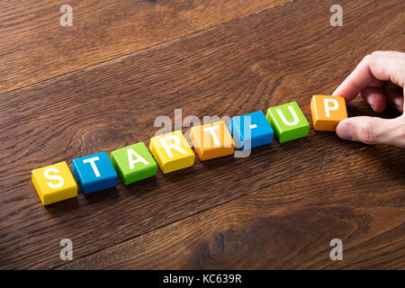 Portrait d'une start-up concept sur les blocs colorés à l'entrepreneuriat concept bureau en bois. Banque D'Images