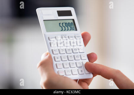 Close-up d'une personne faisant calcul sur calculatrice Banque D'Images