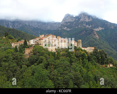 Vue sur le village perché de Pruno entre les pentes boisées sous Monte Forato dans les Alpes Apuanes en Toscane, Italie Banque D'Images