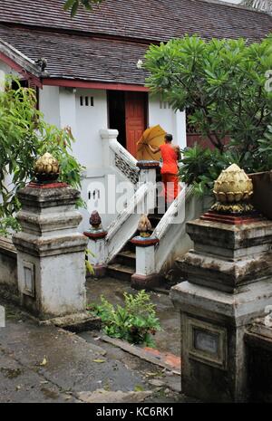 Un moine entre dans chambre, Luang Prabang, Laos Banque D'Images