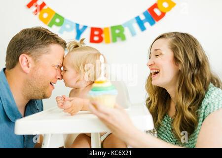 La mère et le père célébrant premier anniversaire de sa fille (12-17 mois) Banque D'Images
