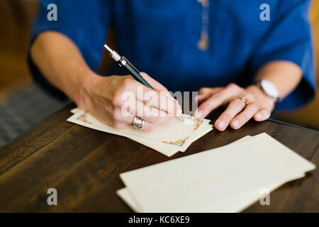 Close-up of woman writing letter Banque D'Images