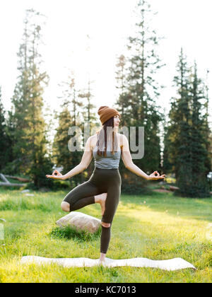 Woman practicing yoga in forest Banque D'Images