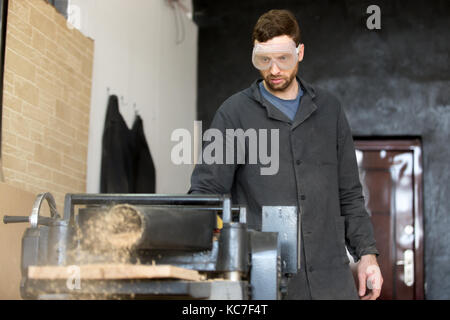 Carpenter en verres de sécurité fonctionne sur machine-outil Banque D'Images