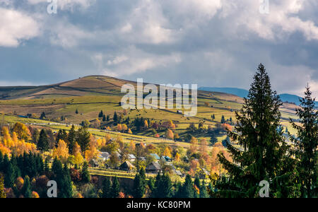 Village sur les pentes de montagnes. une campagne magnifique paysage avec arbres jaunes Banque D'Images