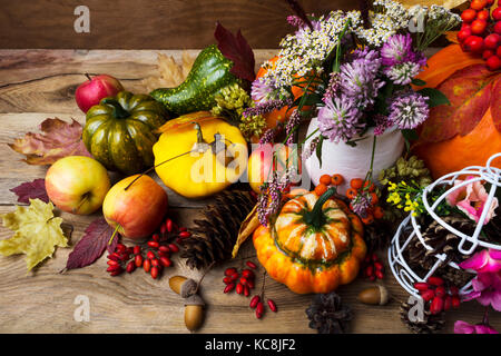 Arrangement d'automne avec le trèfle dans un vase, pommes, petits fruits, légumes et de citrouille, vue du dessus Banque D'Images