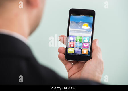 Close-up of Businessman Holding Smartphone avec l'application de couleur Banque D'Images