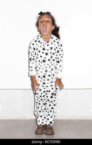 Surpris fille en pyjama sur un fond blanc Banque D'Images