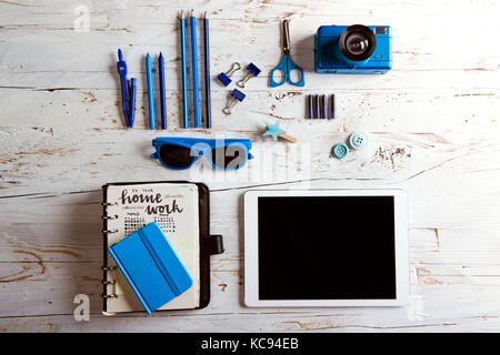 Bureau avec tablette et fournitures scolaires. Studio tourné sur fond de bois blanc. Banque D'Images