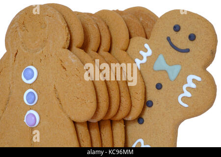 Un line-up de gingerbread men avec l'un d'entre eux debout hors de ligne découper sur fond blanc Banque D'Images