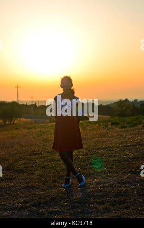 Les jeunes africains-américains touriste avec délicieux blanc et rouge robe jupe rouge admire le paysage toscan pendant le coucher du soleil Banque D'Images