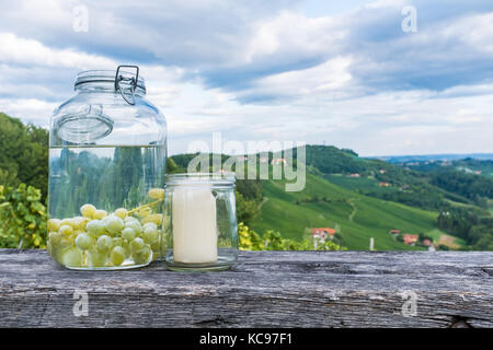 Les pots avec du raisin et bougie sur banc en bois près de vigne le long de la route de la vigne du sud de la Styrie en Autriche, Europe Banque D'Images