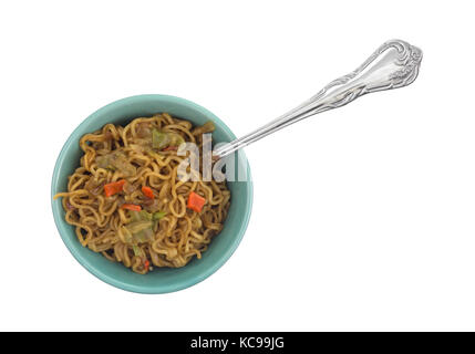 Vue de dessus d'une portion de nouilles ramen saveur de boeuf dans un bol avec une fourchette dans la nourriture isolé sur un fond blanc. Banque D'Images