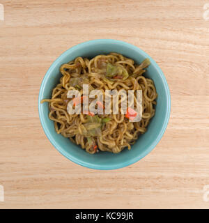 Vue de dessus d'une portion de nouilles ramen saveur de boeuf dans un bol sur une table en bois. Banque D'Images