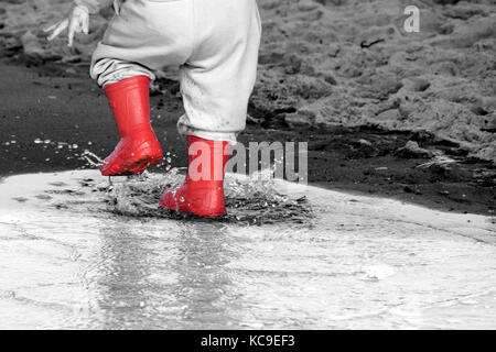 Wellington en flaque.kid bottes en caoutchouc dans le fond de la mer Banque D'Images