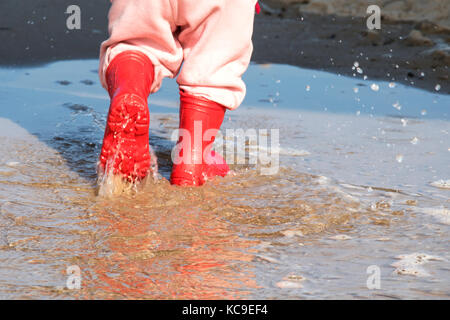 Wellington en flaque.kid bottes en caoutchouc dans le fond de la mer Banque D'Images