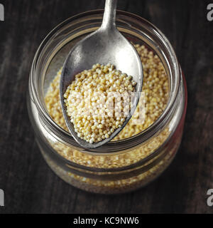 Millet sain biologiques crus dans une cuillère Banque D'Images