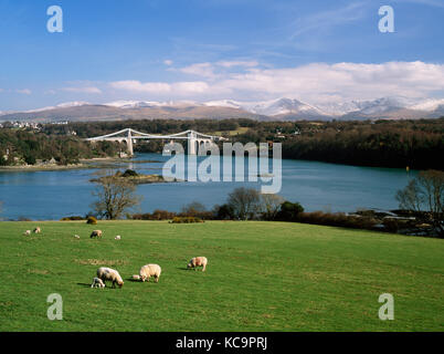 La Menai Bridge, l'église de St Tysilio, et le détroit de Menai. Vue de l'île d'Anglesey au continent, avec Carneddau enneigés des montagnes de Snowdonia. Banque D'Images