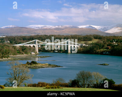 La Menai Bridge, l'église de St Tysilio, et le détroit de Menai. Vue de l'île d'Anglesey au continent, avec Carneddau enneigés des montagnes de Snowdonia. Banque D'Images